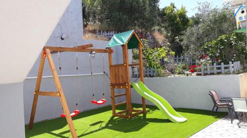 a playground with a slide and a swing set at Vila Blanka in Podgora