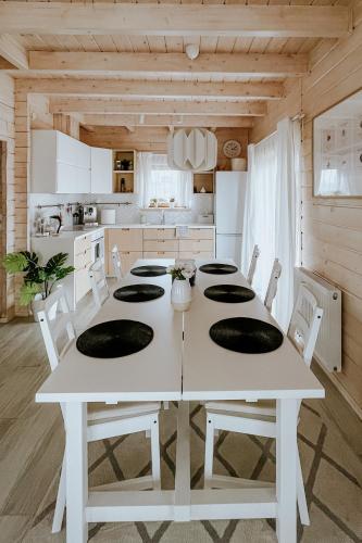 a white kitchen with a white table and chairs at Villa Boguckowianeczka in Ząb
