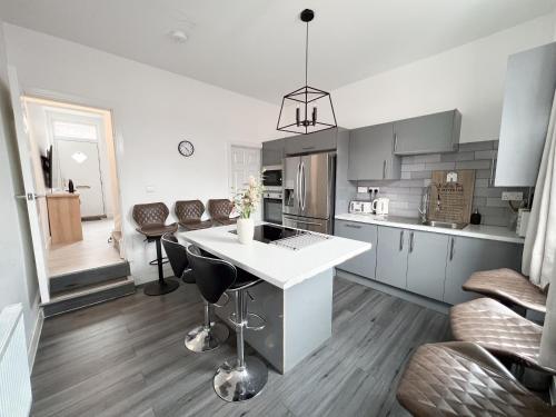 a kitchen with a white island in a room at Modern 4 Bed En-suite House in Leeds - Free parking in Headingley