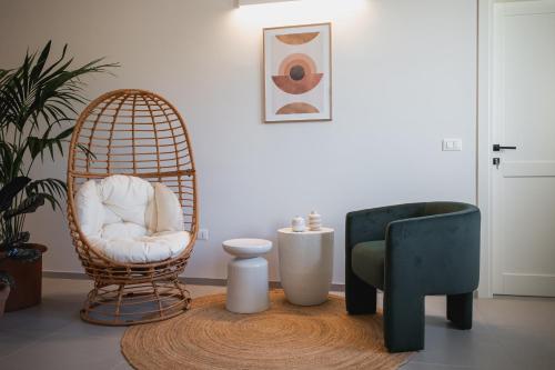 a room with a rattan chair and a stool and a table at Momacasa b&b in Roseto degli Abruzzi