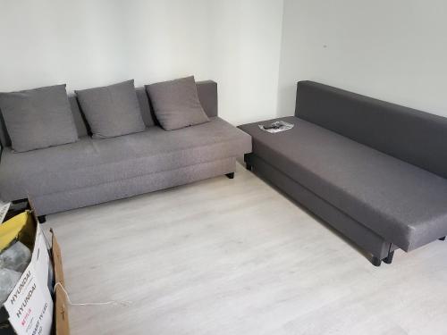 - un canapé installé dans un salon avec un sol dans l'établissement Appartement près de Stade de France, à Aubervilliers