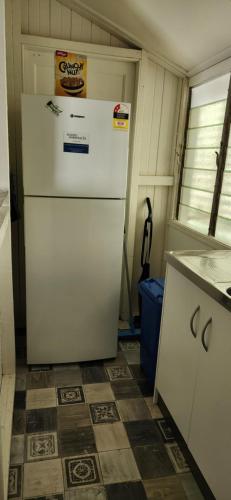 a kitchen with a white refrigerator in a room at Meyenburg Units in Mount Morgan