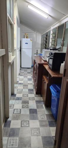 a kitchen with a tile floor with a refrigerator at Meyenburg Units in Mount Morgan