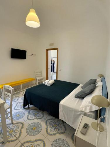 a bedroom with a bed and a tv and a table at Il Vicoletto in Amalfi