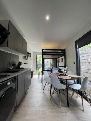 une cuisine avec une table et des chaises dans une pièce dans l'établissement Studio indépendant, Neuf, jardin calme et paisible, à Épinay-sur-Seine
