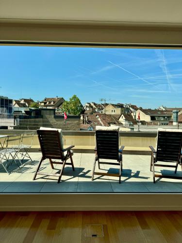 three chairs sitting on a balcony with a view at Exclusive Rooftop Duplex Penthouse - 200sqm - 280 Panoramic Views - Downtown in Basel
