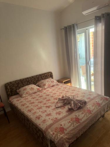 a bed in a room with a window and a bedspread at Vila Almas in Ulcinj