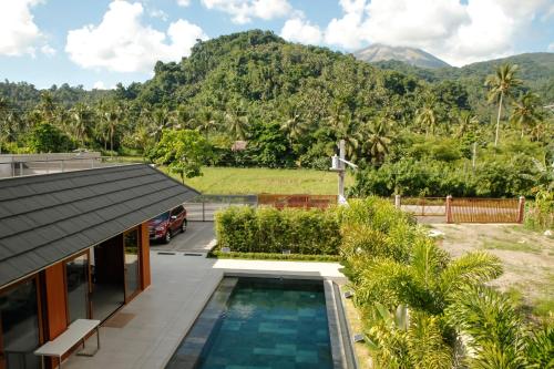 an aerial view of a house with a swimming pool and mountains at The Spring House in Irosin