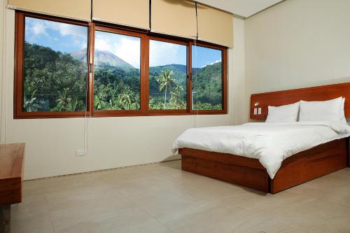 a bedroom with a bed with a view of a mountain at The Spring House in Irosin