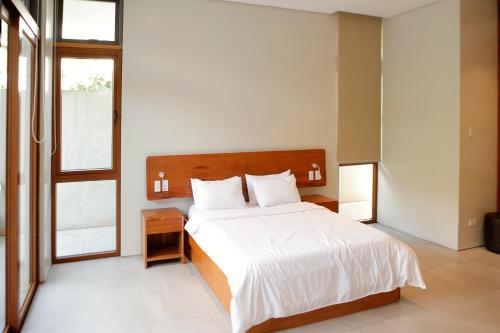a bedroom with a large bed with a wooden headboard at The Spring House in Irosin
