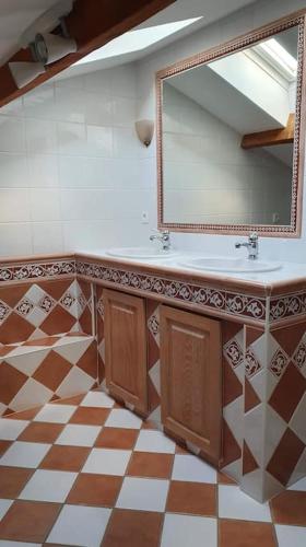 une salle de bain avec un lavabo et un miroir dans l'établissement Maison avec piscine et terrain de pétanque, à Urrugne