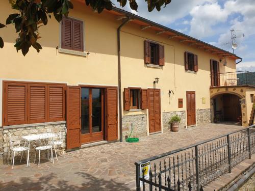 a house with wooden doors and a table and chairs at B&B Il Mandorlo in Cortona