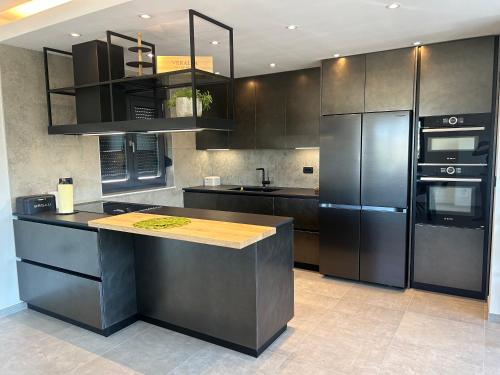 a kitchen with stainless steel appliances and black cabinets at Penthouse HEDONIST with hidromassage bath in Pula
