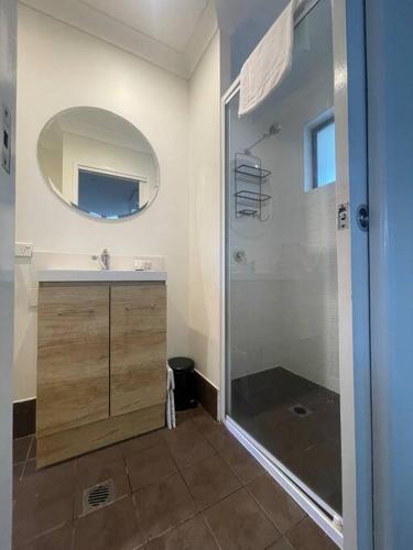 a bathroom with a shower and a sink and a mirror at Cool Cabana Mermaid Beach in Gold Coast