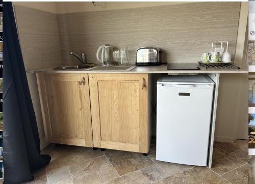 une petite cuisine avec un évier et un réfrigérateur dans l'établissement PORTO VECCHIO Santa Giulia Grand studio bergerie vue exceptionnelle mer et montagne, à Porto-Vecchio