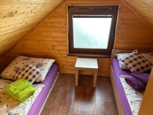 two beds in a room with a window at Nature Lodge in Podkylava