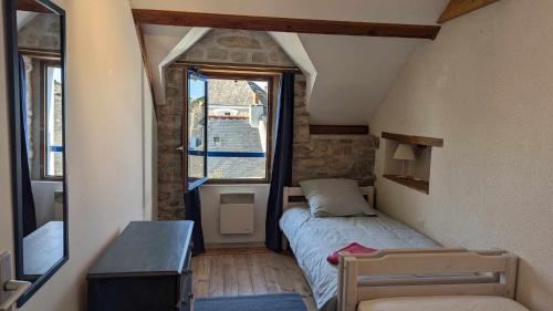 une petite pièce avec un lit et une fenêtre dans l'établissement Ti Maen, à Arzon