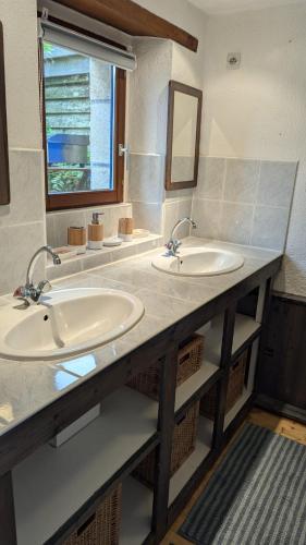 une salle de bain avec deux lavabos et un miroir dans l'établissement Ti Maen, à Arzon