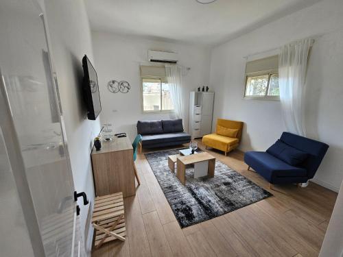 a living room with two blue chairs and a table at Haifa Hadar Urban Apartment in Haifa