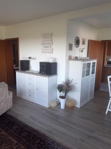 a living room with white cabinets and a kitchen at Ferienwohnungen Sternenhimmel WHG 1 in Medebach
