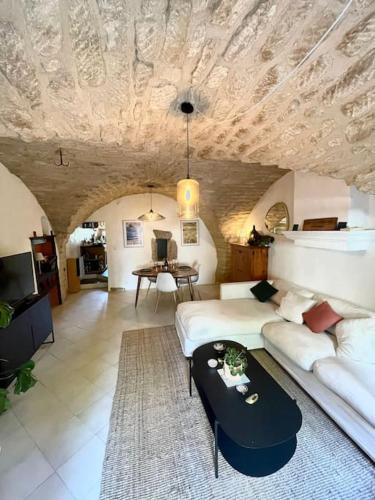 un salon avec un canapé et une table dans l'établissement Charmante maison de village au pied du Lùberon, à Cabrières-dʼAigues