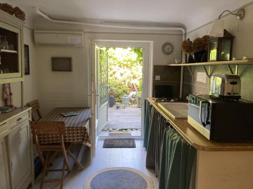 une cuisine avec un évier et une porte donnant sur une cour. dans l'établissement Appartement complet ou 2 Chambres de charme en centre-ville, à Arles