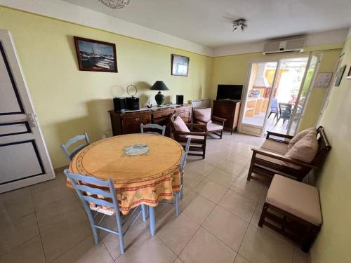 un salon avec une table et des chaises en bois dans l'établissement Entre les citronniers et la mer, à Èze
