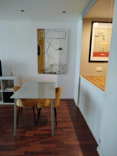 a dining room with a glass table and two chairs at Chic Benalmadena in Benalmádena