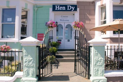 a entrance to a green building with a sign that reads her way at Hen Dy in Llandudno