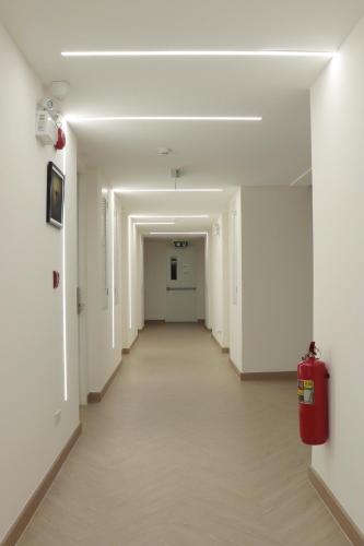 an empty hallway in an office building with a fire extinguisher at ResT Bangkok Poshtel in Bangkok