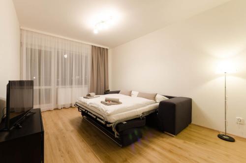 a bedroom with a bed and a flat screen tv at Pension Zličín in Prague