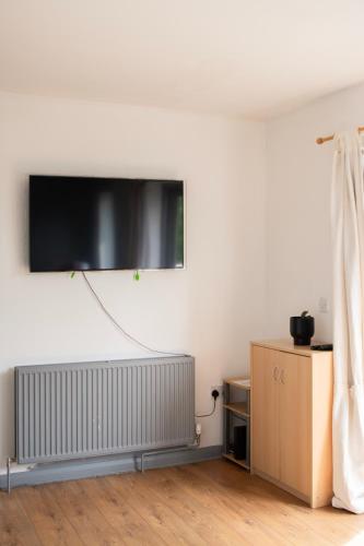 a room with a flat screen tv on a wall at Well-equipped 4 Bedroom House close to City Centre in Leeds