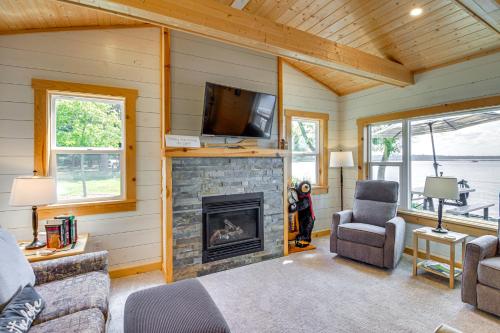a living room with a fireplace and a tv at Lake Hubert Cabin with Private Deck and Boat Dock in Nisswa