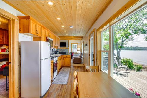 a kitchen with a white refrigerator and a table at Lake Hubert Cabin with Private Deck and Boat Dock in Nisswa