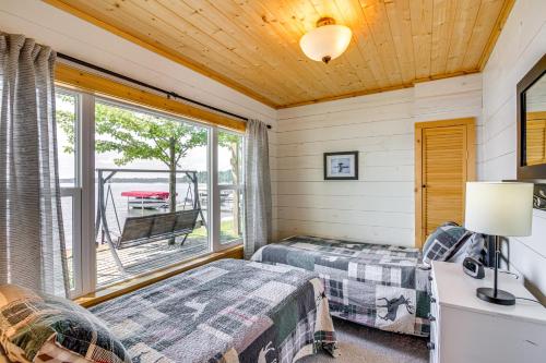 a bedroom with two beds and a window at Lake Hubert Cabin with Private Deck and Boat Dock in Nisswa