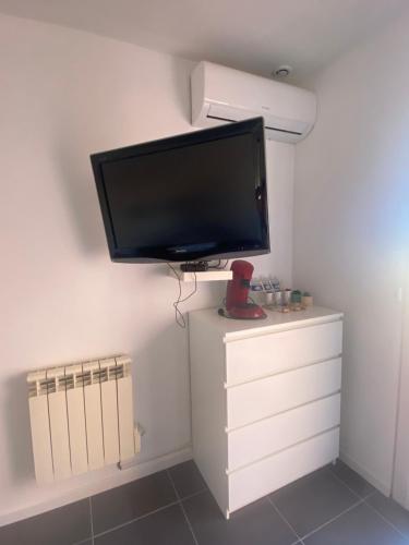 un téléviseur à écran plat posé sur une commode dans l'établissement Chambre tout confort, à Saint-Nazaire