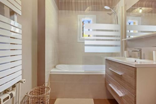 une salle de bain avec une baignoire et un lavabo et une baignoire tubermottermott dans l'établissement Villa St Raphaël, 6 pers, piscine, à Saint-Raphaël
