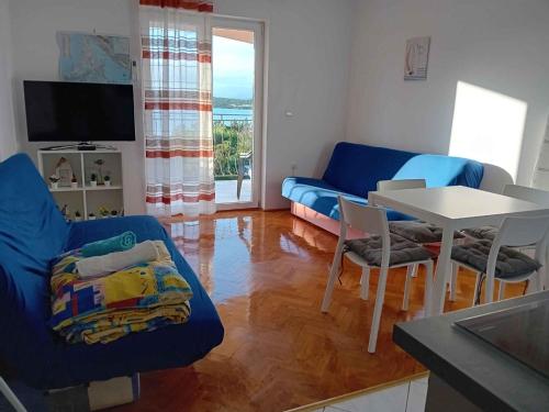 salon z niebieską kanapą i stołem w obiekcie Apartments in Klimno - Insel Krk 12514 w mieście Klimno