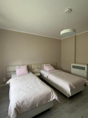 two beds sitting next to each other in a bedroom at Apartament Leśny in Szczejkowice