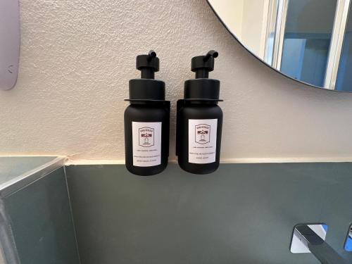 two bottles ofodorizers sitting on a shelf in a bathroom at Domus Socolatae Cocoa Journey Tuscan Lifestyle B&B in Follonica