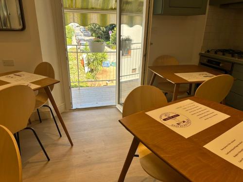 two tables and chairs in a room with a kitchen at Domus Socolatae Cocoa Journey Tuscan Lifestyle B&B in Follonica