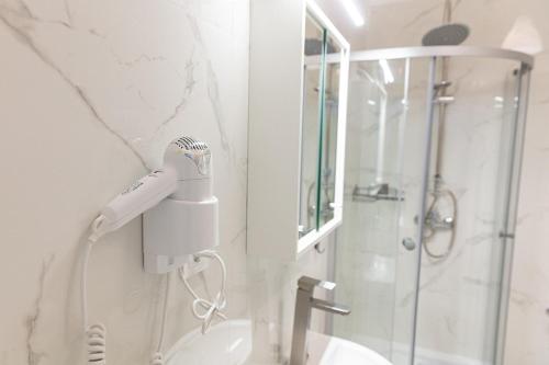 a bathroom with a blow dryer on the wall at Apartamenty Ogrodowa in Zielona Góra