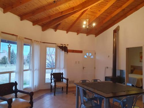a living room with a table and chairs and windows at Las Condalias in Puerto Madryn