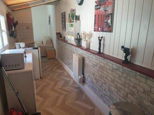 - un salon avec un mur en briques et un comptoir dans l'établissement Petit Studio Centre Cambrai, à Cambrai