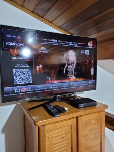 a large flat screen tv sitting on top of a cabinet at Apto Duplex com Mezanino in Juquei
