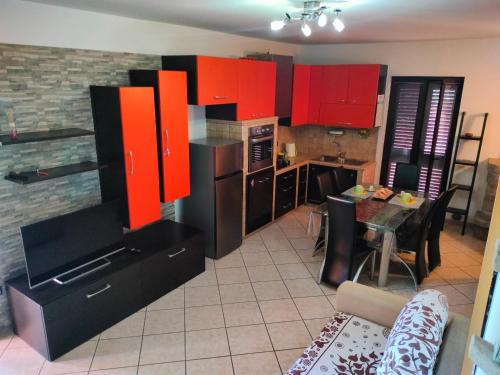 a kitchen with red and black cabinets and a table at Casa Luciana in Santa Maria del Molise