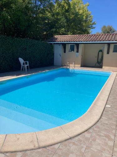 - une piscine bleue avec une chaise à côté d'une maison dans l'établissement Chambre chez l'habitant au calme avec piscinne, à Le Bouscat