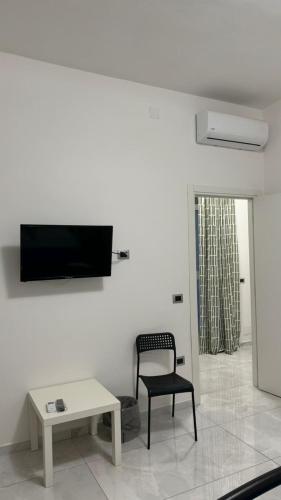 a living room with a chair and a tv on a wall at Rifugio le Palme in Cervino