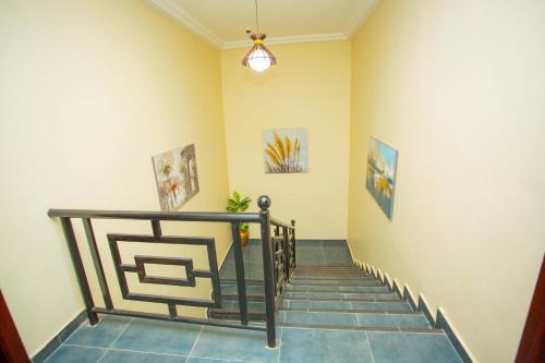 a hallway with a staircase with paintings on the wall at Gateway Lodge in Tamale