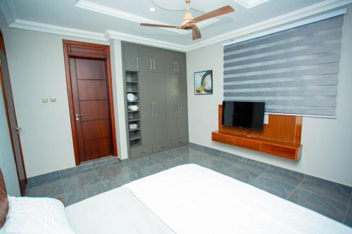 a bedroom with a bed and a flat screen tv at Gateway Lodge in Tamale
